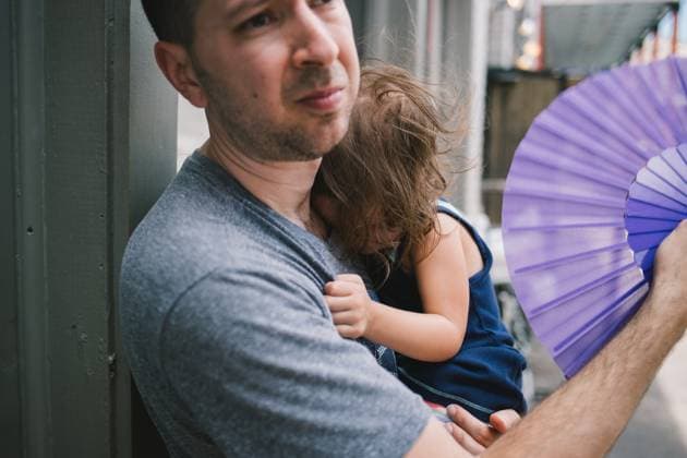 IMAGO Creative, Jahreszeit Sommer, Hitze Man holds sleeping daughter while fanning her on hot summer day New Orleans, Louisiana, United States R_SXFI24031956-1359348-01 ,model released, Symbolfoto