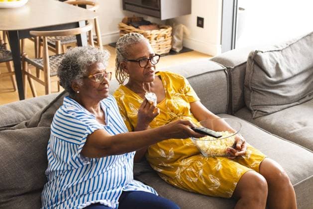 Senior African American woman and senior biracial woman enjoy a movie together, sharing popcorn Senior African American woman and senior biracial woman enjoy a movie together, sharing popcorn. Both are relaxed in a cozy living room, creating a warm, familial atmosphere., model released, , property released, Cape Town, South Africa, 15.11.2023, 4954942.jpg, people,Senior,African American,woman,biracial,enjoy,movie,sharing,popcorn,relaxed,cozy,living room,warm,familial,atmosphere,senior citizens,bonding,leisure,activity,entertainment,diversity,friendship,happiness,grandmother,granddaughter,comfortable,home,generation,connection,love,care,affection,family,together,elderly,multi ethnic,culture,tradition,watching,films,snack,sofa,domestic,copy