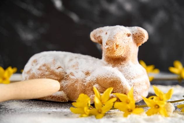 Augsburg, Bavaria, Germany - March 22, 2024: Traditional Easter lamb as a cake for Easter. Baking concept with flour, eggs and fresh yellow flowers *** Traditionelles Osterlamm als Kuchen zu Ostern. Backen Konzept mit Mehl, Eiern und frischen gelben Blumen