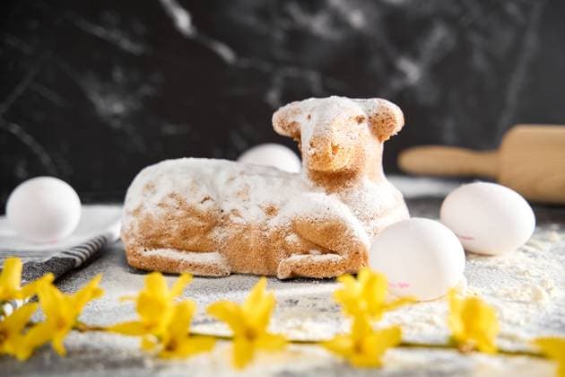 Augsburg, Bavaria, Germany - March 22, 2024: Traditional Easter lamb as a cake for Easter. Baking concept with flour, eggs and fresh yellow flowers *** Traditionelles Osterlamm als Kuchen zu Ostern. Backen Konzept mit Mehl, Eiern und frischen gelben Blumen