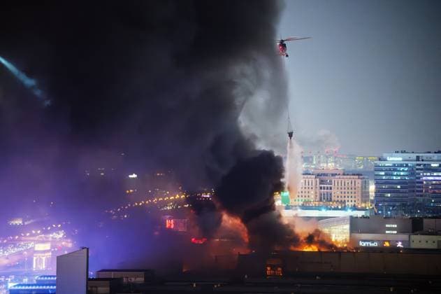 Russia Terrorist Attack 8647908 22.03.2024 Firefighters operate a helicopter as they work to extinguish a fire at the burning Crocus City Hall concert venue following a shooting incident, outside Moscow, Russia. The Russian Federal Security Service (FSB) said that there are people dead and injured as a result of the terrorist attack in the concert hall in Moscow region. A massive fire has also broken out at the venue. Vladimir Sergeev Sputnik Moscow region Russia  Copyright: xVladimirxSergeevx
