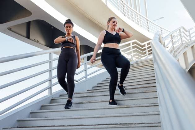 Creative Highlights Symbolbilder Two young females go on the stairs and watch on their smartwatches. Plus-sized woman with her friend looking at smartwatch while stepping down on stairs. Two young females go on the stairs and watch on their smartwatches. Plus-sized woman with her friend looking at smartwatch while stepping down on stairs. Copyright: xxArtemxVarnitsinx