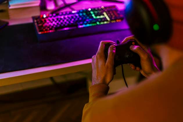 IMAGO Creative, Lifestyle, Gaming Gaming influencer playing video games using controller at home model released, Symbolfoto property released, EGHF00835