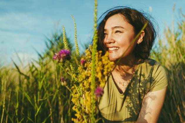 Creative Highlights Symbolbilder Happy woman with bunch of wildflowers in field on sunny day model released, Symbolfoto, IEF00550