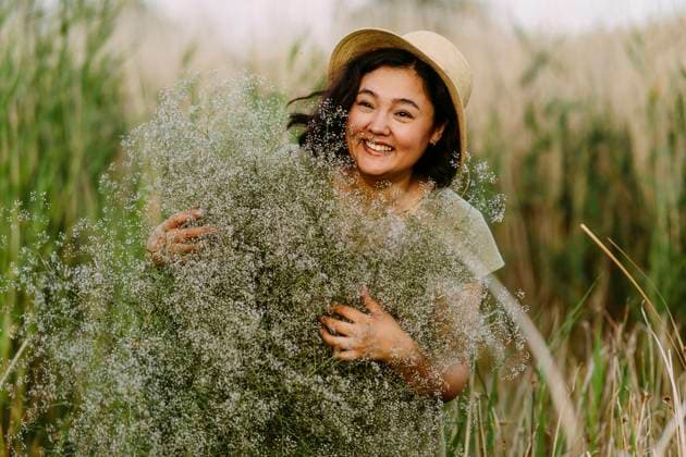 Creative Highlights Symbolbilder Playful woman with bunch of gypsophila flowers in field model released, Symbolfoto, IEF00590