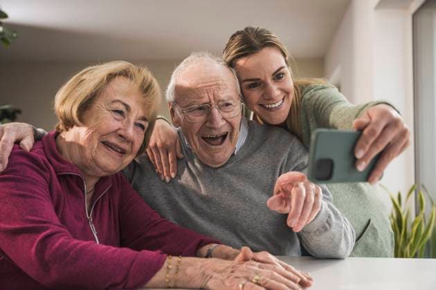 Happy home caregiver taking selfie with senior couple model released, Symbolfoto property released, UUF31176