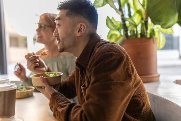 Businessman eating lunch with colleague at office model released, Symbolfoto property released, JCCMF11309