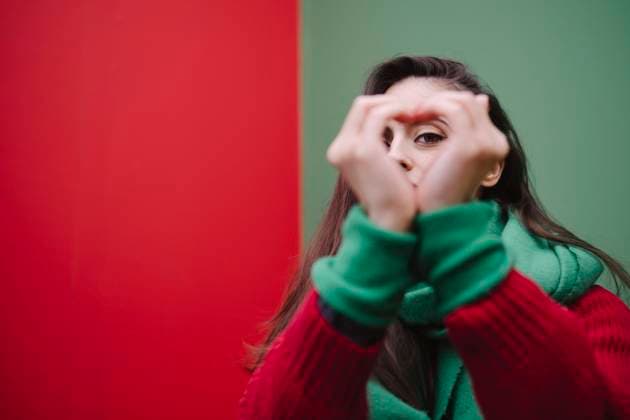 Creative Highlights Symbolbilder Woman making heart shape with hands in front of wall model released, Symbolfoto, AMWF02059