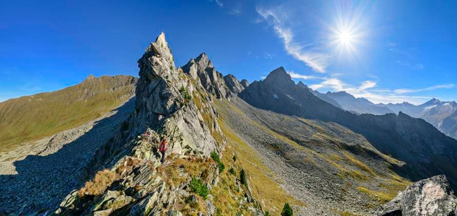 Austria, Tyrol, Sun shining over female hiker following Aschaffenburger Hohenweg trail in Zillertal Alps model released, Symbolfoto, ANSF00735