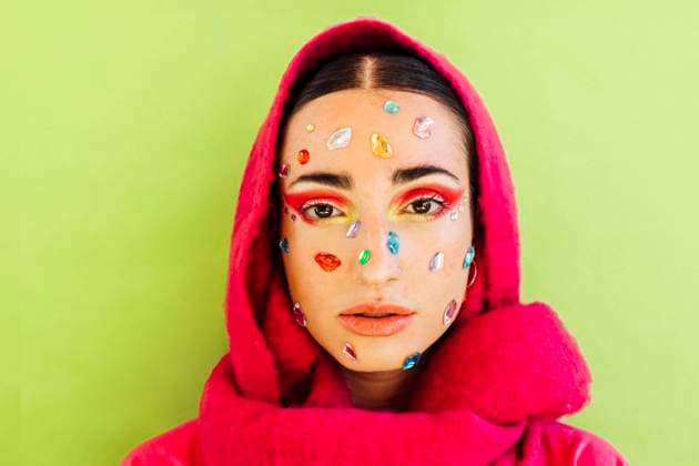 Creative Highlights Symbolbilder Woman with gem stickers on face wearing scarf against green background model released, Symbolfoto, EGHF00851