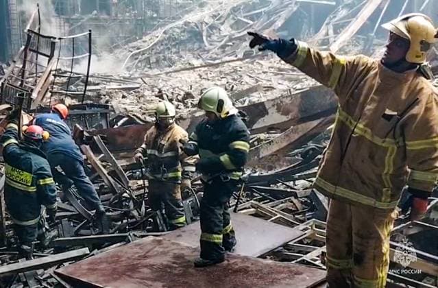 News Themen der Woche KW12 News Bilder des Tages RUSSIA, KRASNOGORSK - MARCH 23, 2024: Employees of the Russian Emergencies Ministry clear the debris at the Crocus City Hall. On March 22, 2024, unidentified gunmen opened fire before the start of a concert at the Crocus City Hall in the town of Krasnogorsk near Moscow, and set off explosives that started a massive fire in the building. The Russian Investigative Committee reports over 100 people dead and over 100 injured. Russian Emergencies Ministry TASS  68477036