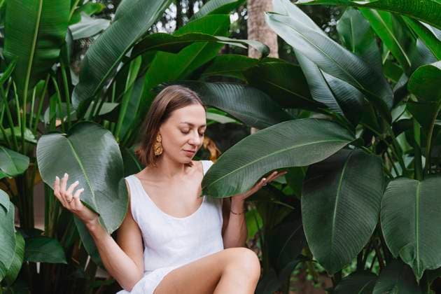 Creative Highlights Symbolbilder Woman with eyes closed sitting near plants model released, Symbolfoto, NDEF01559