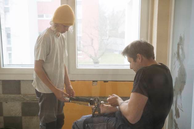 Boy helping father with adjusting caulk gun at home model released, Symbolfoto property released, NJAF00808