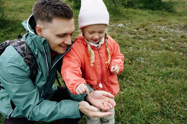 Smiling father showing bug and flower to daughter model released, Symbolfoto, NSTF00037