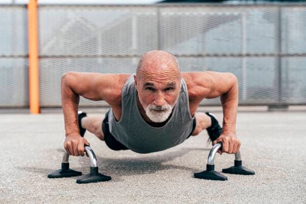 Creative Highlights Symbolbilder Determined senior man doing plank exercise on handles model released, Symbolfoto, OIPF04057
