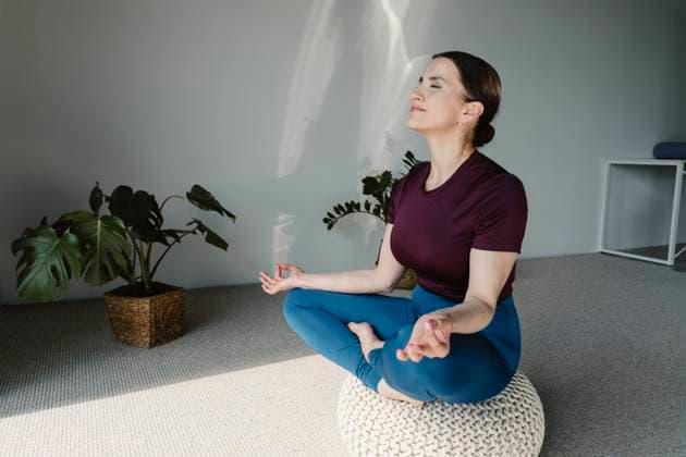 Smiling woman meditating on seat at home model released, Symbolfoto property released, OSF02415
