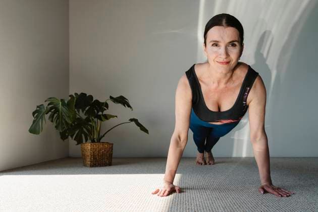 Creative Highlights Symbolbilder Smiling active woman exercising on carpet at home model released, Symbolfoto property released, OSF02419