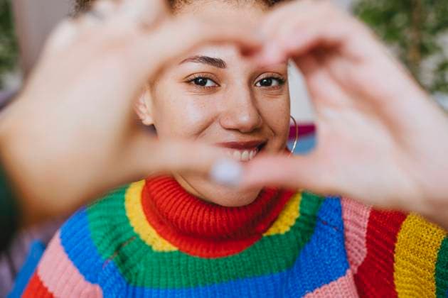 Creative Highlights Symbolbilder Smiling woman gesturing heart shape model released, Symbolfoto property released, YTF01837