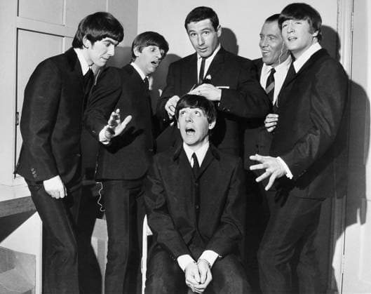 THE BEATLES, 1964. American speed skater Terry McDermott (center), gold medal winner at the 1964 Winter Olympics, attempts to give a haircut to Paul McCartney of the Beatles prior to their appearance on the Ed Sullivan Show in New York City, 9 February 1964, while fellow Beatles, and host Sullivan (behind McDermott), look on.  Copyright: xGRANGERx xGRANGERx 0115146