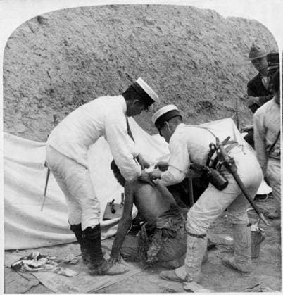 CHINA: BOXER REBELLION, c1901. Two Japanese doctors attending to a wounded man after the Battle of Tientsin, China. Photograph, c1901.  Copyright: xGRANGERx xGRANGERx 0116463