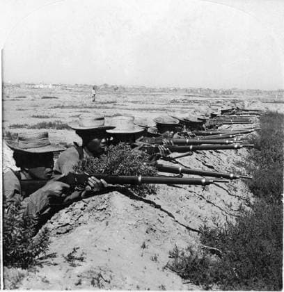 CHINA: BOXER REBELLION. Chinese soldiers firing a volley from the shelter of bank, Tientsin, China. Stereograph, c1900.  Copyright: xGRANGERx xGRANGERx 0116729