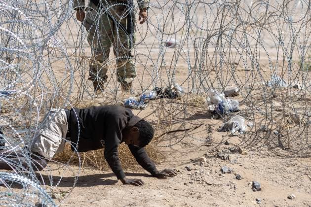 Bilder des Jahres 2024, News 03 März News Themen der Woche KW12 March 24, 2024: A man crawls under the barbed wire after attempting to cross the border, and a Texas National Guard agent orders him to return to Mexico - ZUMAp241 20240324_zip_p241_010 Copyright: xDavidxPeinadox