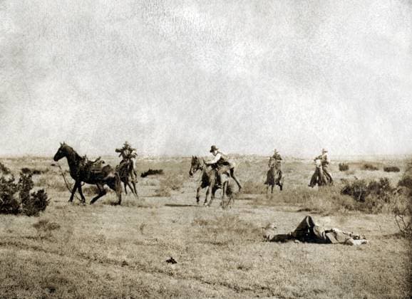 TEXAS: COWBOYS, c1908. A cowboy laying the ground after being thrown from his horse with cowboys on horseback coming to his aid on the Turkey Track Ranch in Texas. Photograph by Erwin Evans Smith, c1908.  Copyright: xGRANGERx xGRANGERx 0124960
