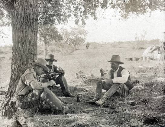 TEXAS: COWBOYS, c1908. Cowboys seated on the ground under a tree and eating dinner at the LS Ranch in Texas. Photograph by Erwin Evans Smith, c1908.  Copyright: xGRANGERx xGRANGERx 0124962
