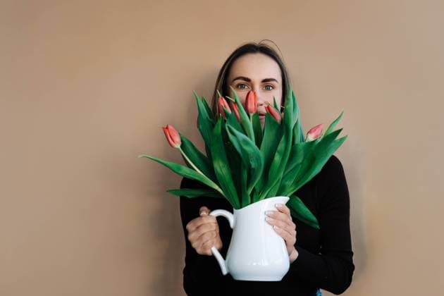 Creative Highlights Symbolbilder Woman holding ceramic white jug serving as vase for bouquet of tulips Vilnius, Vilnius County, Lithuania R_EDSAHG240321-1372168-01 ,model released, Symbolfoto