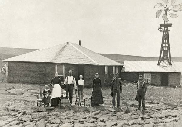 NEBRASKA: SETTLERS, c1885. Family of homesteaders, photographed outside of their sod house with a windmill on the roof of the adjoining building in Custer County, Nebraska. Photograph by Solomon D. Butcher, c1885.  Copyright: xGRANGERx xGRANGERx 0130678