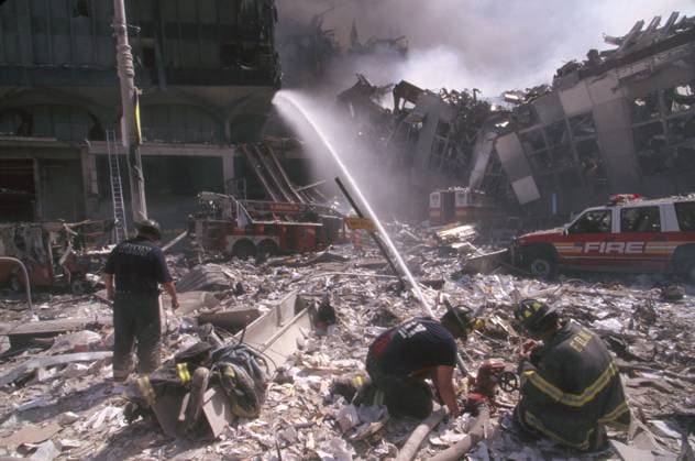 NEW YORK: SEPTEMBER 11TH. A team of firefighters extinguish a fire on a debris-covered street in lower Manhattan, after the terrorist attack on the World Trade Center on 11 September 2001.  Copyright: xGRANGERx xGRANGERx 0170016