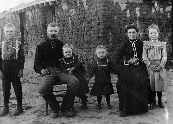 NEBRASKA: SETTLERS, 1900. A homesteader and family in front of their sod house in Cherry County, Nebraska. Photograph by Solomon D. Butcher, 1900.  Copyright: xGRANGERx xGRANGERx 0176472