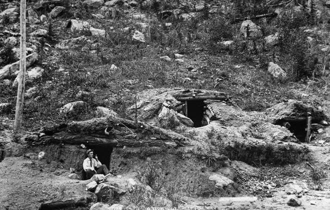 COLORADO: DUGOUT HOME. A man seated outside a dugout cabin at the side of a hill, probably in Colorado. Photographed by William Henry Jackson, c1890.  Copyright: xGRANGERx xGRANGERx 0184168