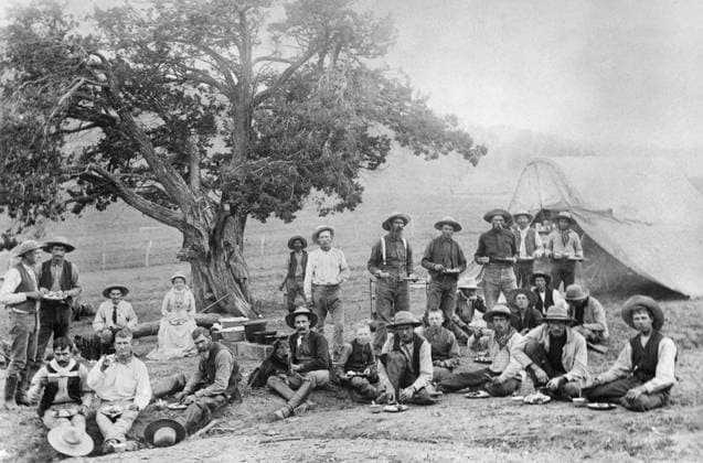 COWBOY CAMP, c1890. Cowboys sitting around a chuckwagon at their camp in Colorado. Photograph, c1890.  Copyright: xGRANGERx xGRANGERx 0186490