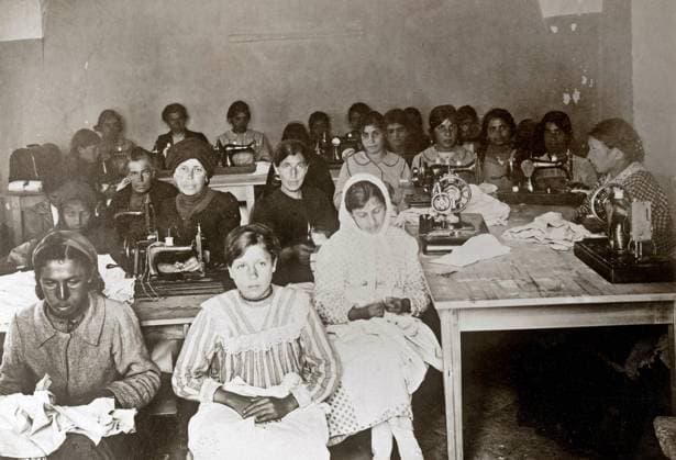 WWI: RED CROSS, 1918. Women and girls at an American Red Cross workroom in Jerusalem, sewing clothing for orphanages and hospitals in Palestine. Photograph, 1918.  Copyright: xGRANGERx xGRANGERx 0528040