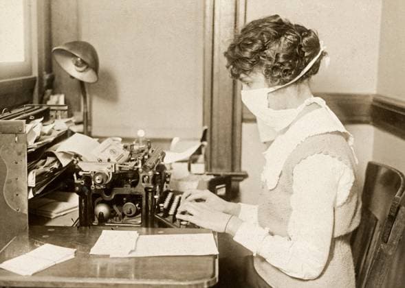 FLU PANDEMIC, 1918. A typist in New York City wearing a face mask during the influenza pandemic. Photograph, October 1918.  Copyright: xGRANGERx xGRANGERx 0529221