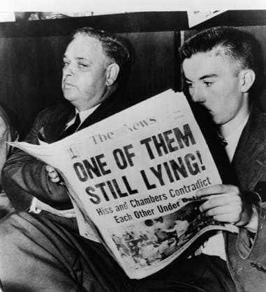 WHITTAKER CHAMBERS (1901-1961). American writer and defected Soviet spy. During the House Un-American Activities Committee investigation of Alger Hiss; the man seated next to Chambers reads a newspaper relating his role in the proceedings. Photograph, 1948.  Copyright: xGRANGERx xGRANGERx 0622959