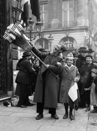 WWI: ARMISTICE, 1918. Flag vendor and boy celebrating the armistice between the Allies and Germany on Rue Saint-Honore in Paris, France. Photograph, 11 November 1918.  Copyright: xGRANGERx xGRANGERx 0642295