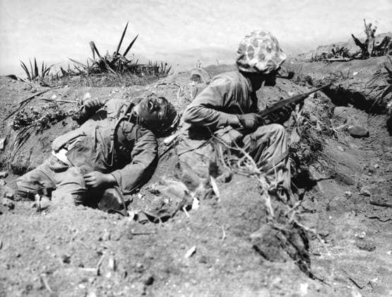 WWII: IWO JIMA, 1945. A Marine crouches in a trench next to the body of a Japanese soldier during the Battle of Iwo Jima. Photograph from the United States Marine Corps, 1945.  Copyright: xGRANGERx xGRANGERx 0644826