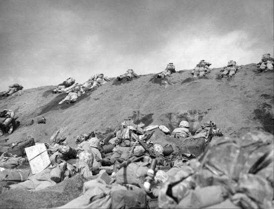 WWII: IWO JIMA, 1945. American Marines using a rise in an Iwo Jima beach for cover during the amphibious landings on the island. Photograph from the United States Marine Corps, February 1945.  Copyright: xGRANGERx xGRANGERx 0644950