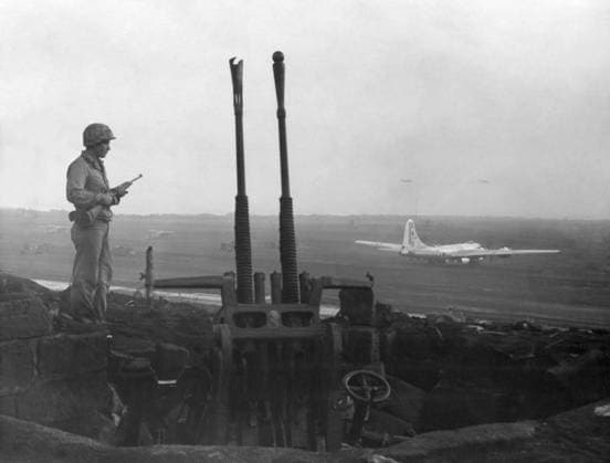WWII: IWO JIMA, 1945. A Marine stands next to a Japanese anti-aircraft gun overlooking Motoyama Airfield, Iwo Jima, which hosts the first B-29 Superfortress to land on the island since its capture by American forces. Photograph from the United States Marine Corps, 1945.  Copyright: xGRANGERx xGRANGERx 0645028