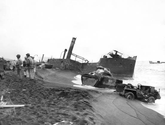 WWII: IWO JIMA, 1945. American Marines stand near wrecked vehicles and a beached Japanese ship during the Battle of Iwo Jima. Photograph from the United States Marine Corps, 1945.  Copyright: xGRANGERx xGRANGERx 0645079