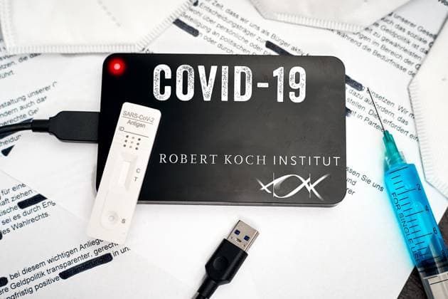 Augsburg, Bavaria, Germany - March 28, 2024: Symbolic photo Robert Koch Institute documents on Covid-19. A hard disk with the inscription Covid-19 and RKI logo lies on blackened documents together with FFP2 masks, syringe and rapid test. PHOTOMONTAGE *** Symbolfoto Robert Koch Institut Dokumente zu Covid-19. Eine Festplatte mit Aufschrift Covid-19 und RKI Logo liegt auf geschwärzten Dokumenten zusammen mit FFP2-Masken, Spritze und Schnelltest. FOTOMONTAGE