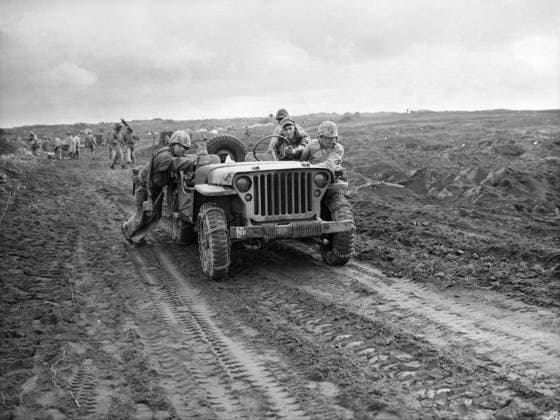 WWII: IWO JIMA, 1945. A group of U.S. Marines pushing a jeep through the sand of an Iwo Jima beach. Photograph, 1945.  Copyright: xGRANGERx xGRANGERx 0650471