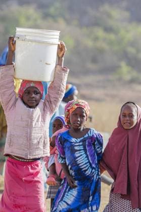 Maedchen traegt einen schweren Wassereimer auf dem Kopf, Maraban Dare, 07.02.2024. Maraban Dare Nigeria *** Girl carrying a heavy water bucket on her head, Maraban Dare, 07 02 2024 Maraban Dare Nigeria Copyright: xUtexGrabowskyxphotothek.dex