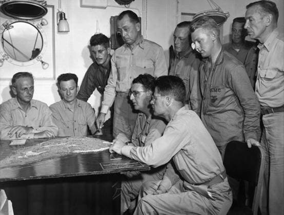 CLIFTON CATES (1893-1970). American Marine Corps officer. Standing center, discussing the planned invasion of Japanese-held Iwo Jima with war correspondents and other officers. Photograph by Karl Thayer Soule, February 1945.  Copyright: xGRANGERx xGRANGERx 0651513