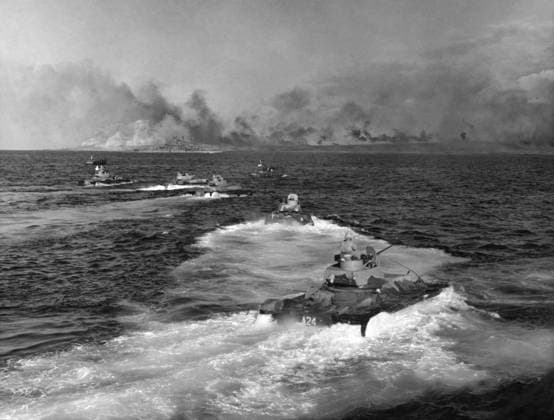 WWII: IWO JIMA, 1945. United States Marine Corps landing vehicles advance towards the beaches of Iwo Jima as an American warship bombards Japanese positions on Mount Suribachi. Photograph by Karl Thayer Soule, February 1945.  Copyright: xGRANGERx xGRANGERx 0651537