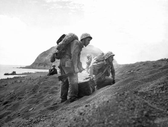WWII: IWO JIMA, 1945. United States marines standing on an Iwo Jima beach during the American invasion of the island; Mount Suirbachi is visible in the distance. Photograph by Karl Thayer Soule, February 1945.  Copyright: xGRANGERx xGRANGERx 0651641