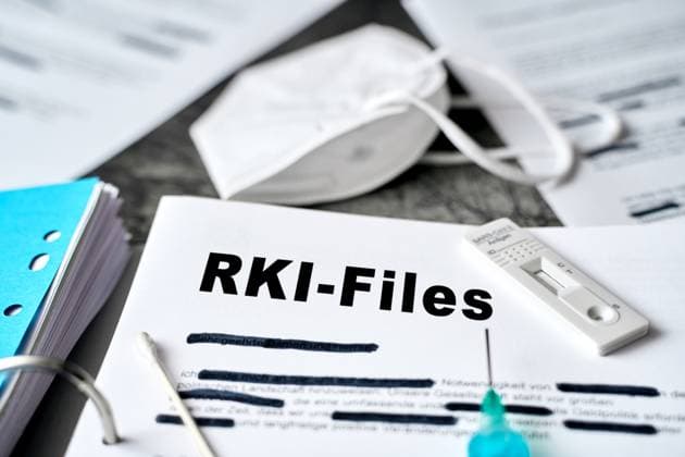 Augsburg, Bavaria, Germany - March 28, 2024: Symbolic photo Robert Koch Institute protocols on Covid-19. An open folder with documents, caption: RKI protocols. PHOTOMONTAGE *** Symbolfoto Robert Koch Institut Protokolle zu Covid-19. Ein geöffneter Ordner mit Dokumenten, Überschrift: RKI-Protokolle. FOTOMONTAGE