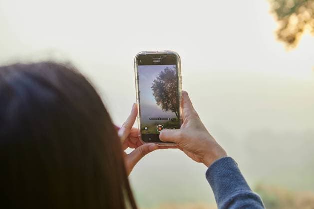 Rear view of woman holding smartphone and taking misty morning Kanchanaburi, Kanchanaburi, Thailand R_GXKV240331-1381527-01 ,model released, Symbolfoto